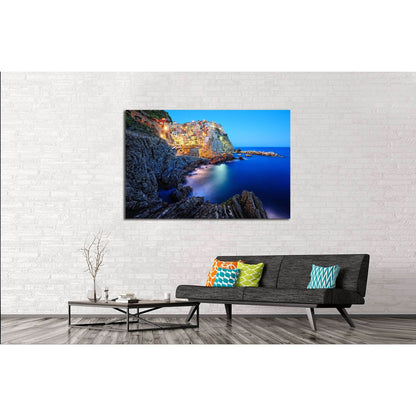 Manarola Cinque Terre Canvas Print - Italian Riviera Wall ArtThis multi-panel canvas print captures the picturesque village of Manarola, part of the Cinque Terre on the Italian Riviera. The vibrant houses perched atop the rugged cliffside, overlooking the